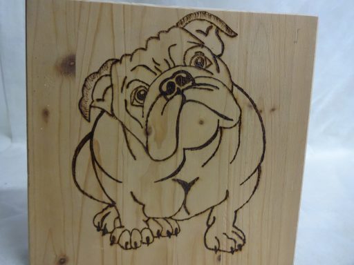 Schilderij van Bulldog op hout Houtsnijwerk van een zittende bulldog met een nieuwsgierige uitstraling.