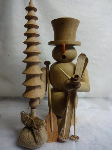 Houten sneeuwpop met kerstboom Houten figuur van een sneeuwman met een hoed, skis, een paddle en een dennenboom.