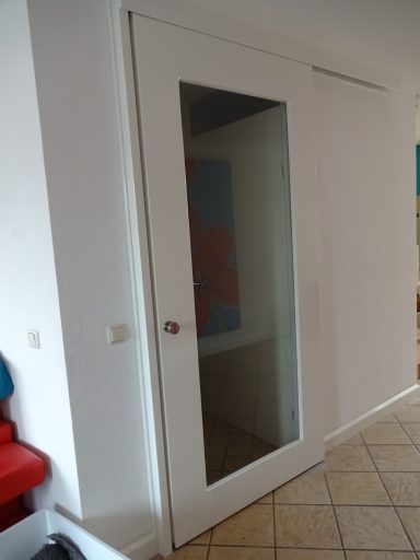 Witte binnen schuifdeur op maat Witte schuifdeur met een glazen paneel, tegen een hoge, witte muur.